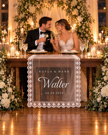 Bride and groom seated at their sweetheart table behind the personalised lace sign