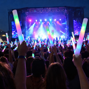 Audience raising lit LED glow sticks at an evening concert